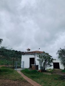 GuadalcanalCasa rural Arroyo Marco的一座白色的建筑,顶部有屋顶