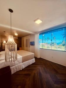 佩德拉斯港Pousada Iandê Patacho的一间卧室设有一张床和一个大窗户