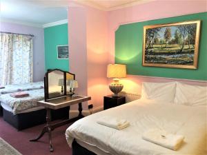 阿克斯桥利特尔顿旅馆的一间卧室配有一张床和一张带镜子的书桌