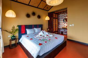 萨帕Sapa Farmstay的一间卧室配有一张红色鲜花的大床