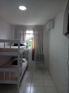 卡马拉吉贝Pousada da Sônia的小房间设有两张双层床和窗户
