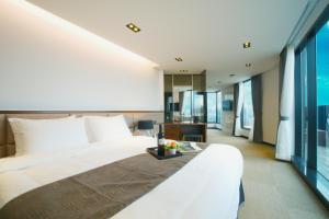 济州市I-Jin Hotel的一间卧室设有一张大床和大窗户