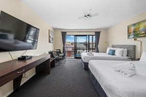 罗托鲁瓦ASURE Rotorua International Motor Inn的酒店客房设有两张床和一台平面电视。