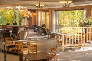 白马村白馬塞拉度假酒店的餐厅设有桌椅和窗户。