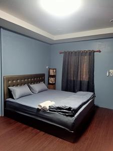 Ban Don Klangเฮือนพรนาคา โฮมสเตย์的一间卧室配有一张大床和黑色床头板