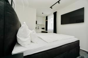 格齐斯Motel by Maier Götzis- kontaktloser Check-in的一间卧室配有一张带白色床单的床和电视。