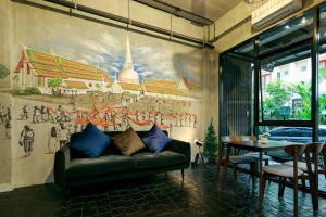 洛坤府เดอะซิกเนเจอร์ นคร โฮเทล的客厅配有沙发和墙上的绘画