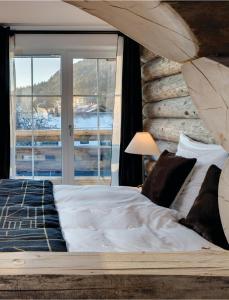 巴特欣德朗MOUNTAIN LODGE OBERJOCH, BAD HINDELANG - moderne Premium Wellness Apartments im Ski- und Wandergebiet Allgäu auf 1200m, Family owned, 2 Apartments mit Privat Sauna的一间卧室设有一张大床和一个窗户。