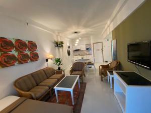 丹绒武雅Seaview Deluxe@Rainbow Paradise Tg Bungah 4-6pax的客厅配有沙发和桌子