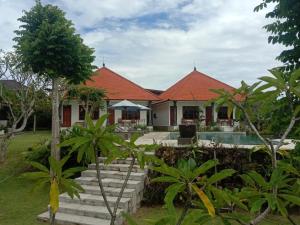 乌鲁瓦图Batu Jaran Hill Cottage Uluwatu的一座带橙色屋顶的房屋