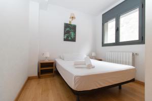 卡尼略卡尼略3000公寓的卧室配有白色的床和窗户。