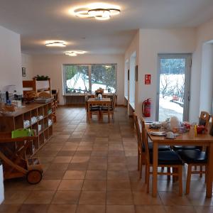 RoppenPension Alpina的厨房以及带桌椅的用餐室。