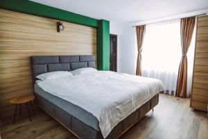 兰卡Altitude Guest House Ranca的一间卧室设有一张大床和绿色的墙壁