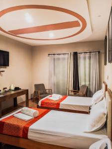 塔那那利佛Valiha Hotel Antananarivo的配有2张床的酒店客房 - 带天花板