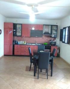 伦蒂尼Independent apartment from Vincenza的厨房配有红色橱柜和桌椅