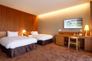 樱井市Hotel Nara Sakurai No Sato的酒店客房设有两张床和一台墙上的电视。