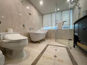 台北玩行旅大安分馆的带浴缸、卫生间和浴缸的浴室。