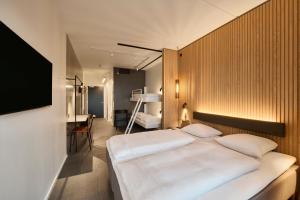 瓦埃勒Zleep Hotel Vejle的卧室配有一张白色大床和一张书桌