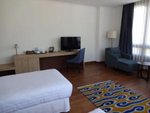 廷布不丹廷布沃瑟酒店的酒店客房配有一张床、一张桌子和一把椅子。