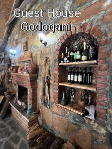 GodoganiGuest House Godogani的一间设有砖砌壁炉的房间,配有一束葡萄酒瓶