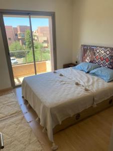 马拉喀什Prestigia jade Marrakech ENTREE 191 APPARTEMENT 9的一间卧室设有一张床和一个大窗户