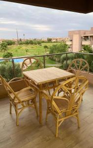 马拉喀什Prestigia jade Marrakech ENTREE 191 APPARTEMENT 9的阳台上的木桌和椅子