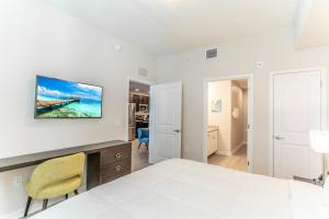 奥兰多4013 Vista Cay 2的白色卧室配有床、书桌和椅子