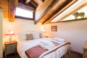 勒沙布勒Charming Old Barn Converted Into A Cosy And Stylish Home的卧室配有白色床和天窗