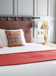 莱斯特Castle Hotel by Chef & Brewer Collection的一张带红色毯子的床和一张桌子上的灯