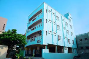 蓬蒂切里Sri Apartment 2BHK For Familys Couples Parking A1的城市里高大的蓝色建筑
