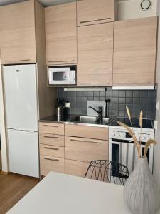 赫尔辛基Lovely studio in the famous Design District area.的厨房配有白色冰箱和炉灶。
