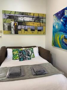 努萨维尔Luxury Top Floor Sunset Villa的一张带两个枕头的床和墙上的绘画