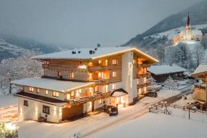 菲根Hotel Garni Romantik的一座大雪地建筑,山中