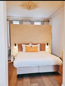 奥斯坦德Villa Ostinato的一间卧室配有一张带两盏灯的大型白色床。