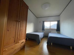 ShimotakaiFive Peaks Ryuoo的一间小卧室,配有两张床和窗户