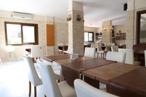 达利安Hotel Binlik的用餐室配有木桌和白色椅子