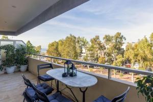 雅典Glyfada Center Sea View Apt的设有一个配有桌椅并享有美景的阳台。