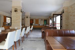达利安Hotel Binlik的用餐室配有木桌和白色椅子