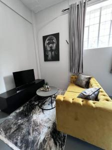 约翰内斯堡`Luxury Cosy City Apartment的客厅配有黄色的沙发和桌子