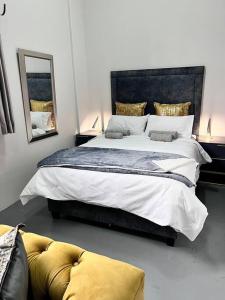 约翰内斯堡`Luxury Cosy City Apartment的一间卧室配有一张大床和镜子