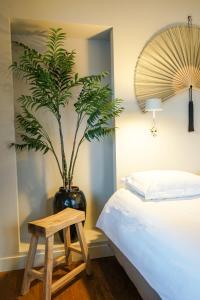 蒂尔堡Villa la Vida的卧室,在床边的花瓶里种植植物