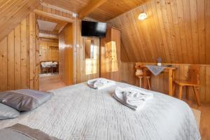 布泽吉Villa Kucówka的一间卧室配有一张带木墙的大床