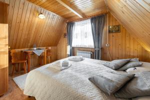 布泽吉Villa Kucówka的木制客房内的一间卧室配有一张大床