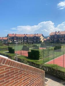 柯米拉斯Apartamento Nuria Comillas的一个带房屋的网球场和网球场