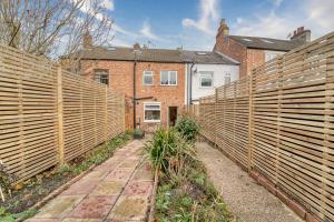 莱斯特Guest Homes - Loughborough Road House的房屋前带木栅栏的花园