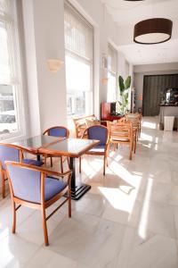 锡切斯苏布尔酒店的用餐室配有木桌和蓝色椅子