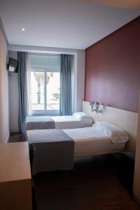 瓦伦西亚环球酒店的酒店客房设有两张床和窗户。