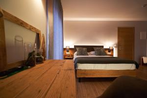 阿夏戈Hotel Ristorante Pennar的一间卧室配有一张床,铺有木地板
