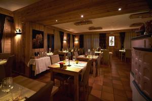 阿夏戈Hotel Ristorante Pennar的一间在房间内配有桌椅的餐厅