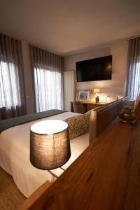 阿夏戈Hotel Ristorante Pennar的酒店客房设有一张大床和一张桌子。